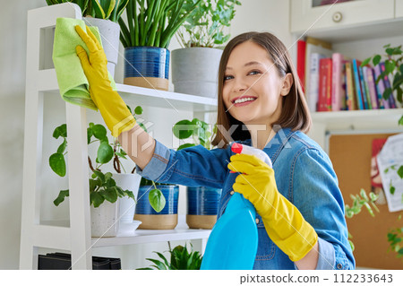Young woman cleaning house, wearing gloves with cleaning spray and rag Young woman cleaning house, wearing gloves with cleaning spray and rag 112233643