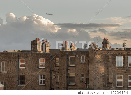 Rear view of urban brick apartment buildings and old houses in london with sky background at evening. 112234194