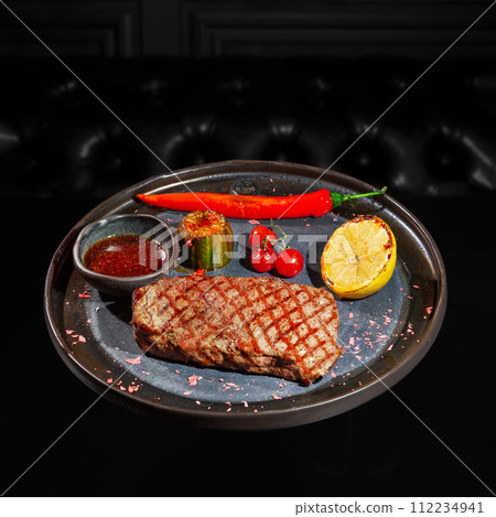 Fried huge striploin beef steak with hot red chilly pepper and cabbage and small tomatoes Fried huge striploin beef steak with hot red chilly pepper and cabbage and small tomatoes 112234941