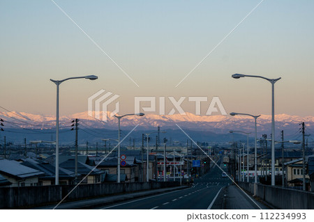 Mountains bathed in the morning glow seen from the overpass 112234993