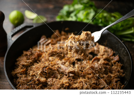 carnitas in skillet pan with tacos ingredients carnitas in skillet pan with tacos ingredients 112235443