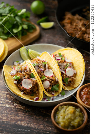 carnitas tacos with salsa and lime 112235452