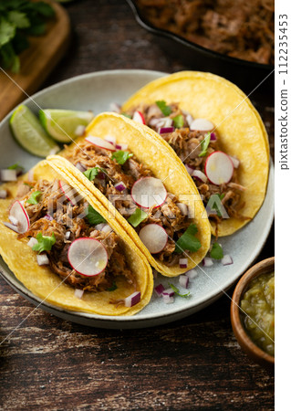 carnitas tacos with salsa and lime 112235453