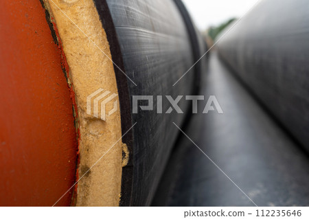 Steel pipe with heat insulation on construction site close up 112235646