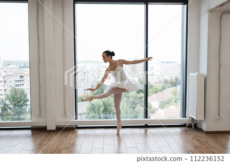 Caucasian ballerina posing in bright class studio with panoramic windows 112236152