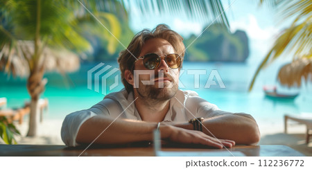 Young man sitting in a bar at the beach 112236772