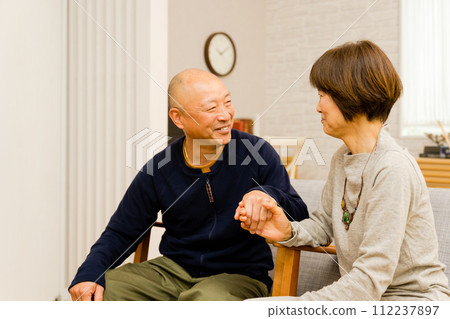 兩對年長夫婦手牽手,在室內害羞地看著對方 兩對年長夫婦手牽手,在室內害羞地看著對方 112237897