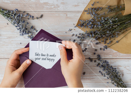 TAKE TIME TO MAKE YOUR SOUL HAPPY text on supportive message paper note reminder from green envelope. Flat lay composition dry lavender flowers. Concept of inner happiness, slowing-down digital detox TAKE TIME TO MAKE YOUR SOUL HAPPY text on supportive message paper note reminder from green envelope. Flat lay composition dry lavender flowers. Concept of inner happiness, slowing-down digital detox 112238206