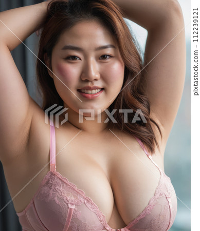 an asian woman in pink lingerie posing for the camera 112239121