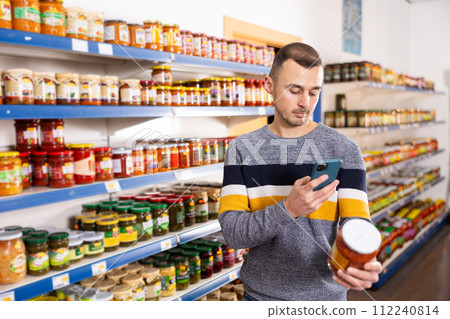 Adult man with mobile phone chooses lecho 112240814