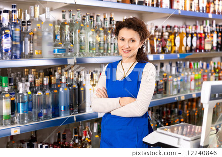 Woman works as salesperson in alcohol department of Russian store. 112240846
