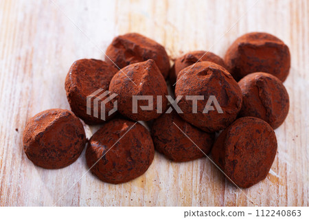 Chocolate truffle candies on wooden table 112240863