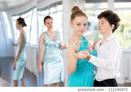 Motivated adolescent ballroom dancers practicing dance moves in studio 112240872