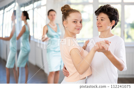 Girl and a boy are having fun learning to dance tango at choreographic school Girl and a boy are having fun learning to dance tango at choreographic school 112241075