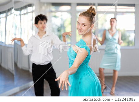 Girl and boy in evening dresses learn to dance the foxtrot in choreographic studio Girl and boy in evening dresses learn to dance the foxtrot in choreographic studio 112241092