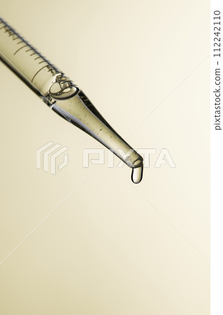Clear liquid droplets falling from a dropper that can be used for cosmetic and medical images. Clear liquid droplets falling from a dropper that can be used for cosmetic and medical images. 112242110