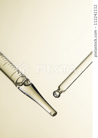 Clear liquid droplets falling from a dropper that can be used for cosmetic and medical images. 112242112