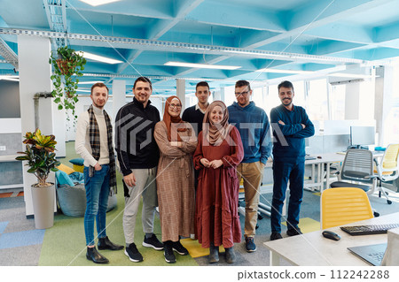 Portrait of a successful creative businessman and businesswoman looking at camera and smiling. Diverse business people standing together at startup. 112242288