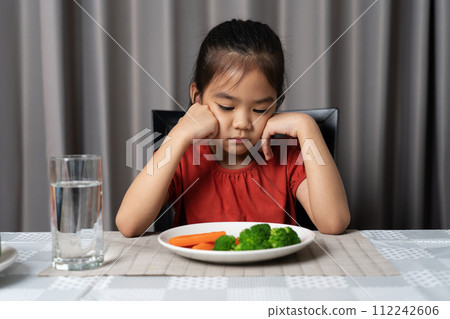 Little cute kid girl refusing to eat healthy vegetables. Children do not like to eat vegetables. Little cute kid girl refusing to eat healthy vegetables. Children do not like to eat vegetables. 112242606