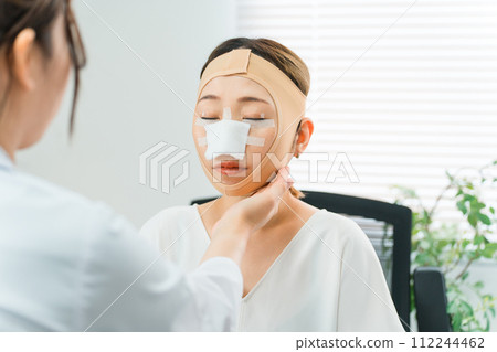 一名婦女在整容診所接受整形手術，手術後接受醫生檢查 112244462