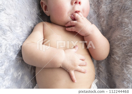 Close-up of shirtless baby sucking a pacifier Close-up of shirtless baby sucking a pacifier 112244468
