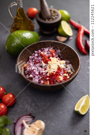 Cooking traditional salsa - sliced chopped ingredients in a wooden bowl Cooking traditional salsa - sliced chopped ingredients in a wooden bowl 112245621