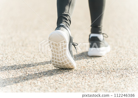 Feet walking in running/walking shoes 112246386
