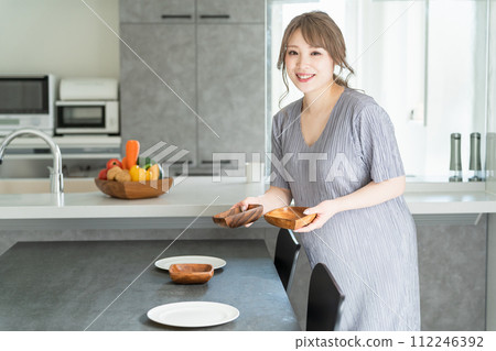 亞洲婦女、孕婦和懷孕母親在廚房和餐廳準備和提供飯菜 亞洲婦女、孕婦和懷孕母親在廚房和餐廳準備和提供飯菜 112246392