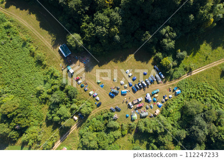 Aerial drone view of outdoor camp with tents and cars 112247233