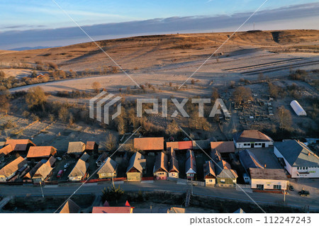 Aerial view of residential houses in a village during morning sunrise lights Aerial view of residential houses in a village during morning sunrise lights 112247243