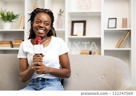 Smiling Afro American Woman Blogging with Microphone at Home Smiling Afro American Woman Blogging with Microphone at Home 112247569