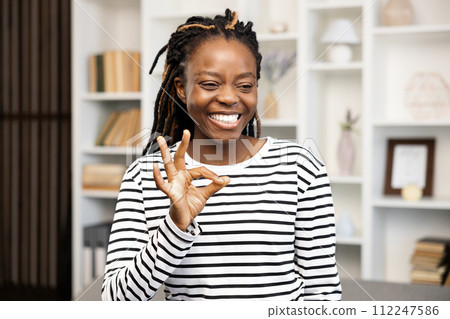 Happy Woman Gesturing Ok Sign at Home 112247586