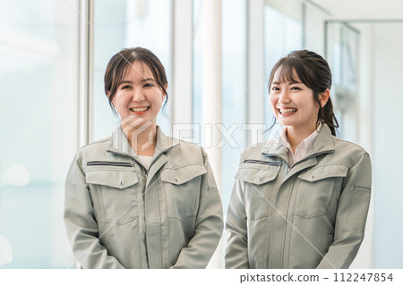 Female staff in the manufacturing, building, transportation, and construction industries wearing work clothes. 112247854