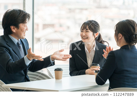 Businessmen and women chatting in the office cafe space Businessmen and women chatting in the office cafe space 112247889