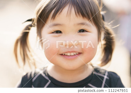 Close-up of a girl smiling in the park 112247931