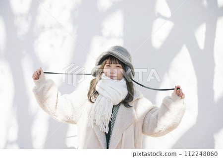 穿著冬衣的年輕女子站在樹影下 穿著冬衣的年輕女子站在樹影下 112248060