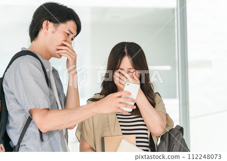 Students/university men and women who are shocked when they look at their smartphones (sad news, news of death, bad news, failure) Students/university men and women who are shocked when they look at their smartphones (sad news, news of death, bad news, failure) 112248073