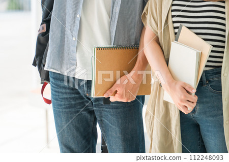College student/student in casual clothes holding a notebook 112248093