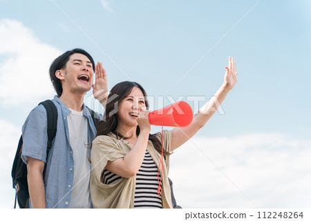 藍天下年輕的亞洲男女透過擴音器歡呼、歡呼、歡呼 112248264