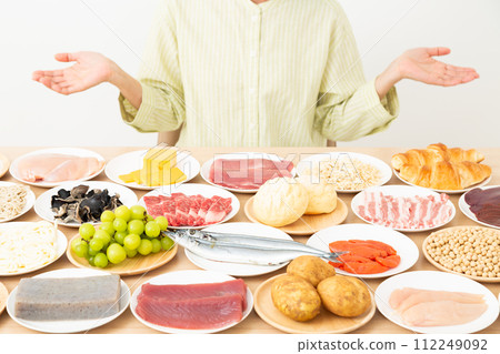 A middle-aged woman with various ingredients and her hands 112249092