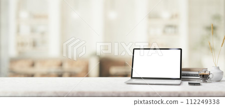 A white marble table features a white-screen laptop mockup in a contemporary, cosy coffee shop. A white marble table features a white-screen laptop mockup in a contemporary, cosy coffee shop. 112249338