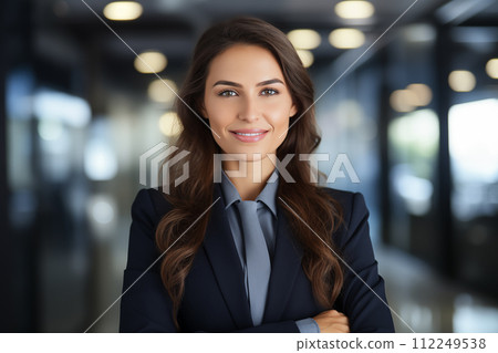 Portrait of young businesswoman with crossed arms standing in office. Portrait of young businesswoman with crossed arms standing in office. 112249538