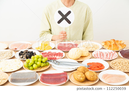 一位中年婦女用各種配料做十字標誌 112250039