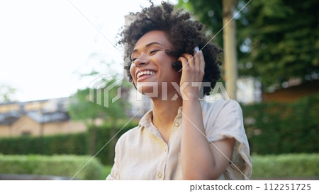 Beautiful biracial woman enjoying favourite music in headphones, catching the rhythm 112251725