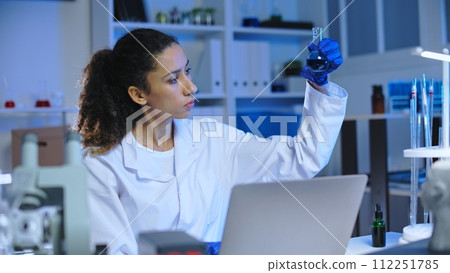 Medical lab scientists examining fluid samples in test tubes, work on research 112251785