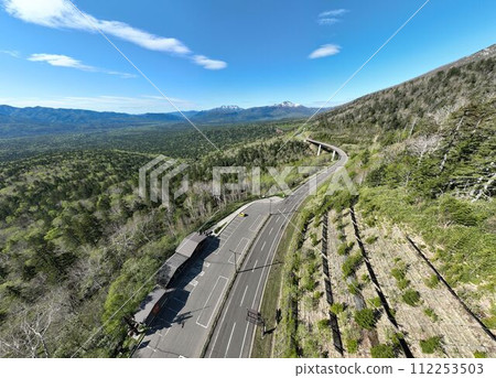 Aerial photograph of Mikuni Pass and Matsumi Ohashi Bridge overlooking the Aokigahara forest of the Daisetsuzan Mountains, Hokkaido. Aerial photograph of Mikuni Pass and Matsumi Ohashi Bridge overlooking the Aokigahara forest of the Daisetsuzan Mountains, Hokkaido. 112253503