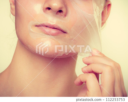 Woman removing facial peel off mask. 112253753