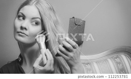 Attractive woman applying make up with brush. Attractive woman applying make up with brush. 112253781