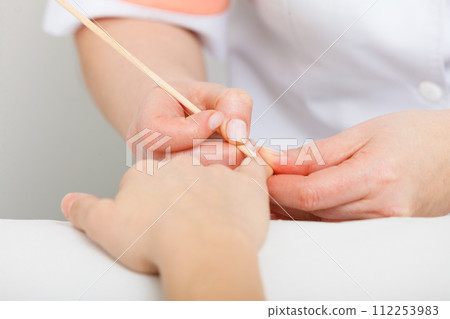 Preparing nails before manicure, pushing back cuticles Preparing nails before manicure, pushing back cuticles 112253983