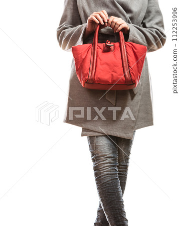 woman in gray coat holds red handbag 112253996